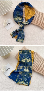 Close-up of navy and yellow floral silk scarf tied elegantly on a wooden tray decor
