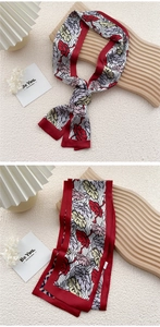 Detail of floral silk scarf showing vibrant red patterns and elegant knotted texture