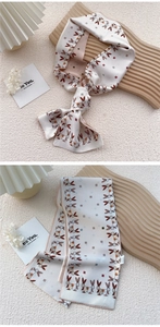 Detail of a floral rabbit print silk skinny scarf tied as a stylish fashion hair ribbon