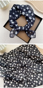 Detailed macro of daisy floral print on a sheer black cotton linen neck scarf
