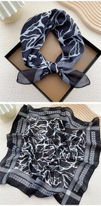 Detail of a chic black and white linen neckerchief with abstract zebra patterns in a gift box