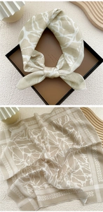 Detail of elegant beige cotton linen scarf with coral patterns in a gift box packaging