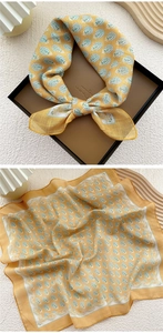 Close-up of yellow cotton linen square scarf with paisley pattern and rolled edges