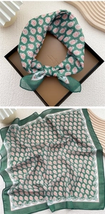 Detailed view of dark green paisley square scarf showing texture and pattern layout