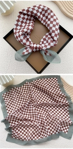 Detail of red and white checkered cotton linen scarf with grey-green border texture