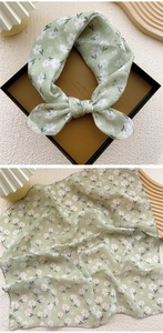 Detail view of light green floral cotton linen scarf with soft pink flower patterns