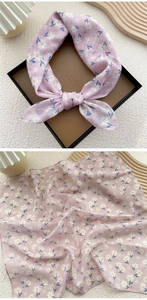 Detail of pink cotton linen square scarf with delicate floral print and soft fabric texture