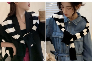 Détail d'un châle en tricot rayé noir et blanc porté sur des tenues à la mode