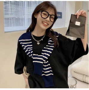 Detailed texture of blue and white striped knitted shawl draped over a black T-shirt