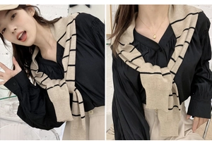 Detail showing khaki and black striped knitted shawl draped over a black shirt