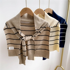 Detailed close-up of striped knit shawl fabric texture and woven brand care label