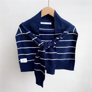 Detail of striped knitted shawl showing blue and white patterns with wooden hanger