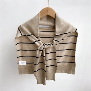 Close-up of striped knit shawl with material labels showing polyester and wool blend
