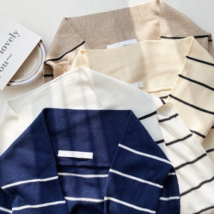 Striped knit shawl scarves displayed in navy, beige, cream, and khaki with elegant shadows
