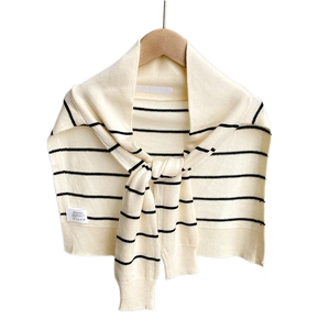 Striped knit shoulder wrap scarf in cream and black hanging on a wooden hanger