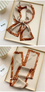 Detail of elegant beige and caramel skinny silk scarf with white floral print patterns