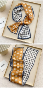 Detailed macro view of orange floral and blue houndstooth pattern double-sided silk scarf