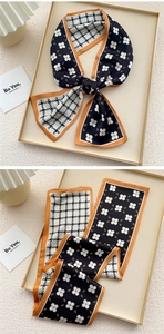 Detail of skinny silk scarf with houndstooth and floral print with orange borders