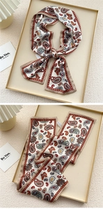 Close-up of narrow silk scarf featuring vintage red and blue paisley print with dots