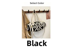 Detail of black and white cylinder bag with geometric texture on a wooden hanger
