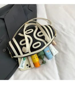 Detail view of cylinder crossbody bag showing large capacity for cosmetics and phone