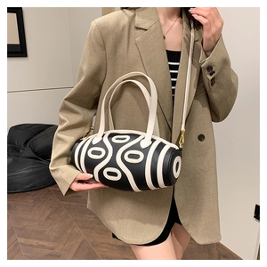 Detail of Boston-style cylinder handbag with black pebbled leather and geometric patterns