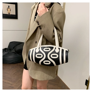Detail of a cylinder leather shoulder bag with chic black and white contrast pattern
