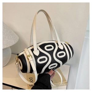Detail of Boston bag featuring black lychee leather with white contrast stitching