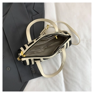 Internal layout of striped handbag showing zippered pockets and gold hardware details
