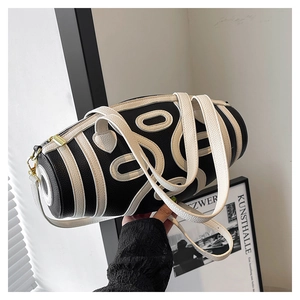 Detail of lychee pattern leather bag with white abstract oval applique and gold zipper