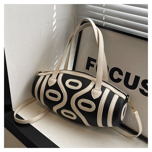 Detail of a cylindrical two-tone bag featuring lychee texture and focus decor backdrop