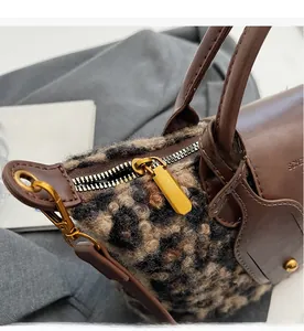 Detailed close-up of the smooth gold-toned zipper on the leopard print plush bag