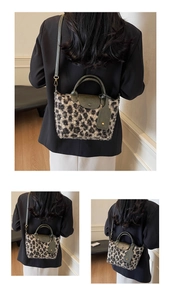 Detailed view of vintage leopard print plush handbag with green leather trim and strap