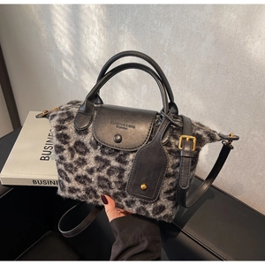 Close-up of leopard print faux fur tote with leather handles and metal hardware detail