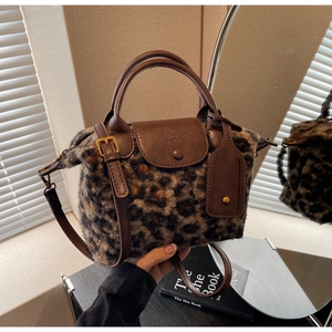 Detail of leopard print faux fur handbag with brown leather flap and adjustable strap
