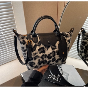 Detail of black and white leopard print faux fur handbag with black leather flap and gold hardware