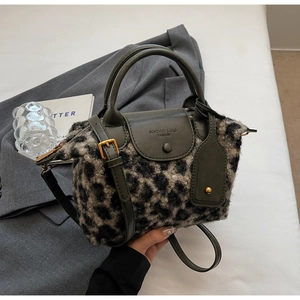 Detail of leopard print plush texture and olive green leather strap on handbag