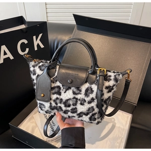 Detail of leopard print faux fur handbag with black leather flap and logo engraving