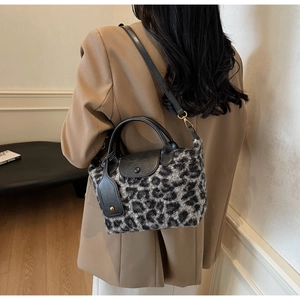 Detailed close-up of leopard print handbag with leather flap and gold hardware accents
