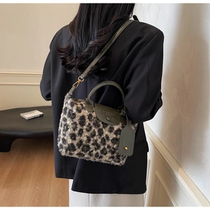 Macro shot of leopard faux fur texture and olive green leather details on handbag