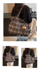 Detail of vintage plaid tote bag featuring a baseball glove pendant and wool fabric texture
