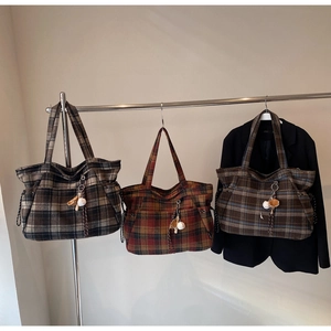 Close-up of three vintage plaid woolen tote bags with drawstring details and baseball charms