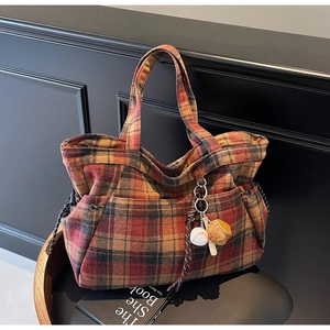 Detail of vintage plaid tote bag with side drawstrings and baseball glove charm