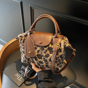 Leopard print faux fur handbag with brown leather straps and adjustable shoulder strap