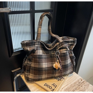 Detail of vintage brown plaid wool tote bag with baseball charms on book