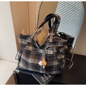 Close-up of vintage plaid tote bag with brown wool fabric and sports charms