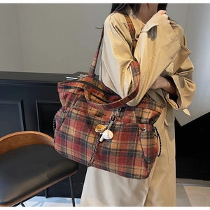 Detail of vintage plaid tote bag with baseball charm and drawstring side accents