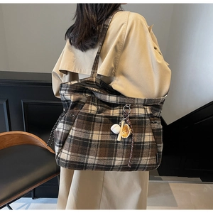 Detail of vintage plaid wool tote bag with creative baseball charm and thick fabric texture