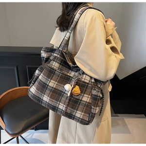 Detailed view of plaid wool tote bag with classic pattern and decorative accessories