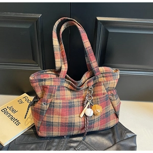 Detail of vintage plaid tote bag featuring red wool fabric and a baseball bat keychain